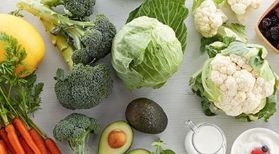 An assortment of healthy produce to prepare in recipes, including carrots, avocados and broccoli