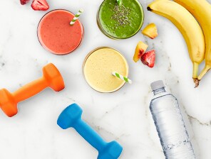Water bottle and colorful dumbbells, smoothies, and fruits